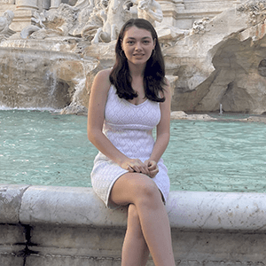 Paige Callaghan sitting in front of the Trevi Fountain