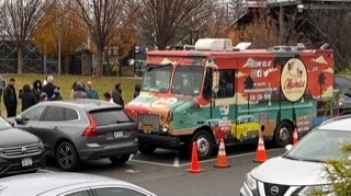 Food truck parked in lot serving people food
