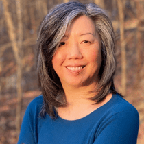 Headshot of Erika Lee standing outside and wearing a blue shirt.