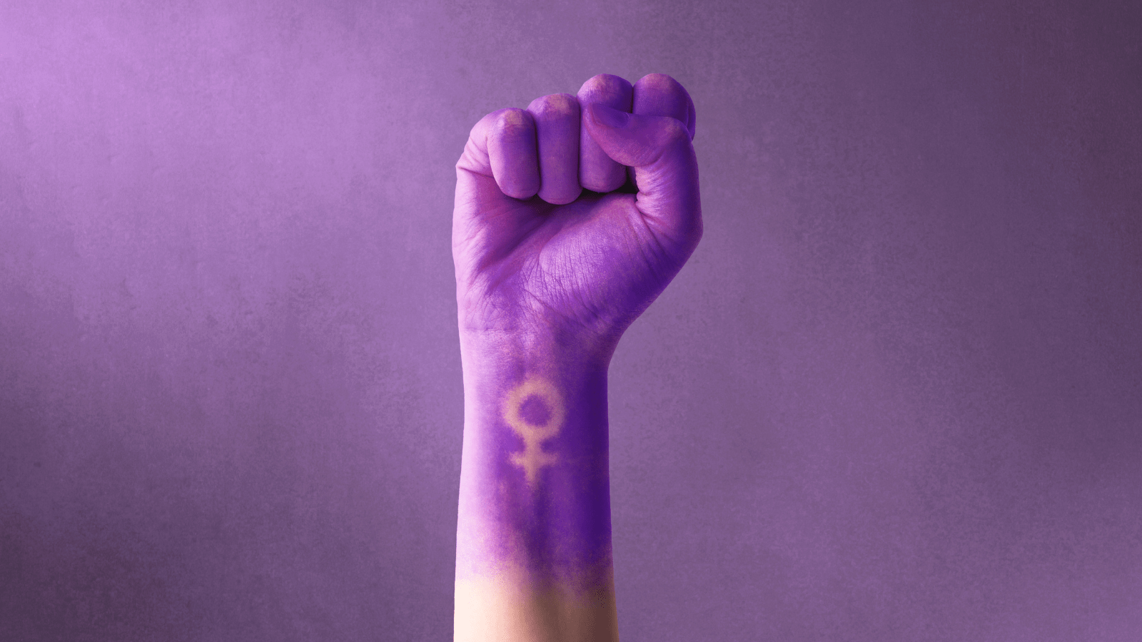  Raised purple fist of a woman for international women's day and the feminist movement. March 8 for feminism, independence, freedom, empowerment, and activism for women rights