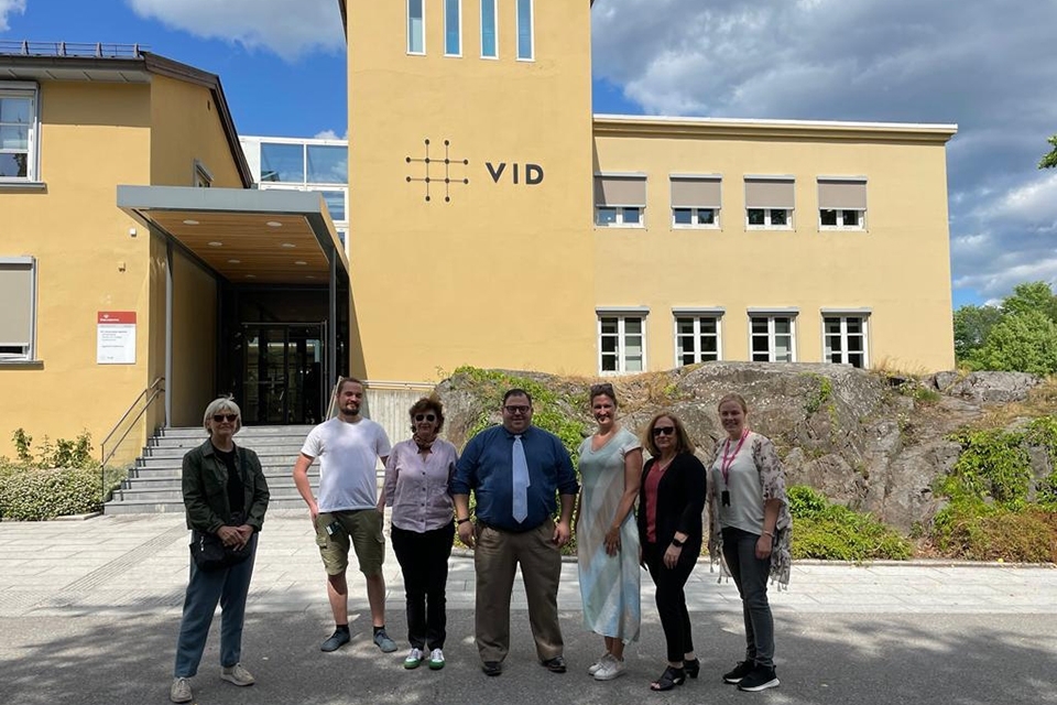 St. John's employees pose for photo in front of VID facility