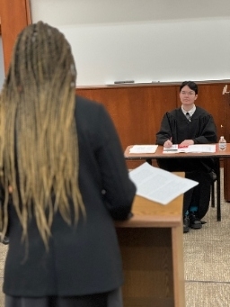 Student and judge interact in mock trial program.