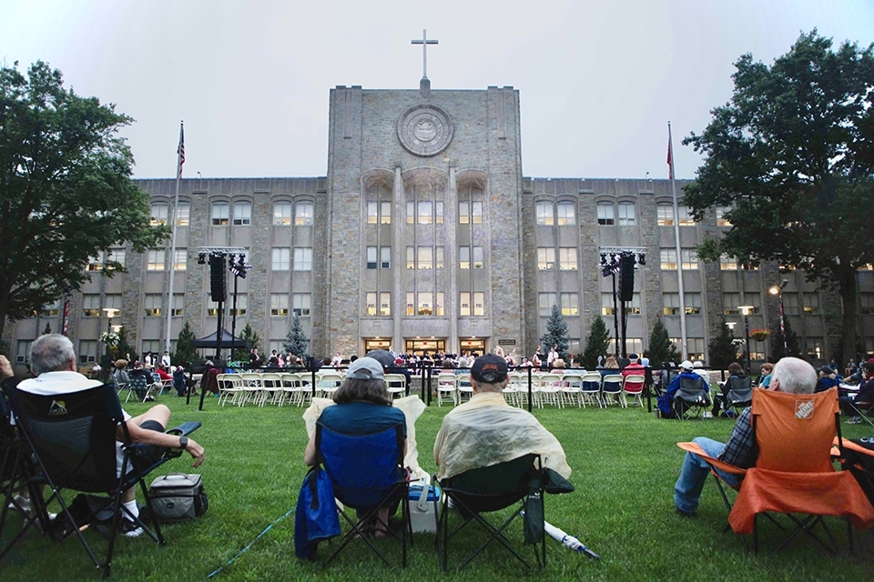 Concert goers sitting in lawn chairs facing the stage on the Great Lawn