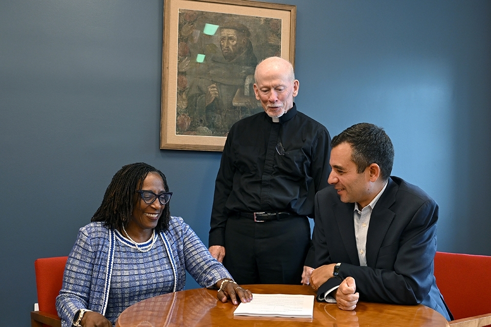 Terryl Brown and man seated at table, with Fr. Shanley standing behind them