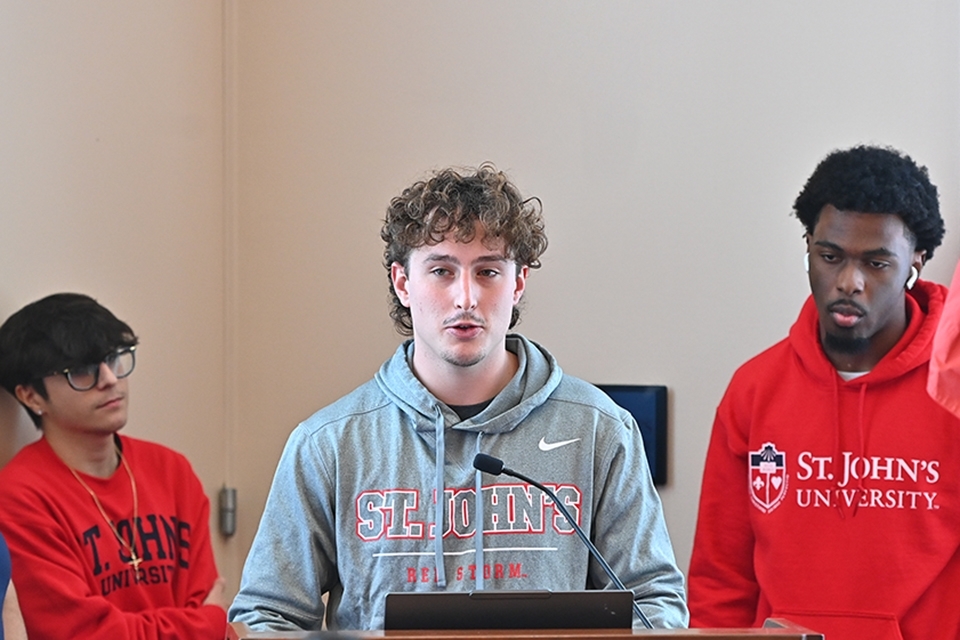 Three male high school students speaking at podium