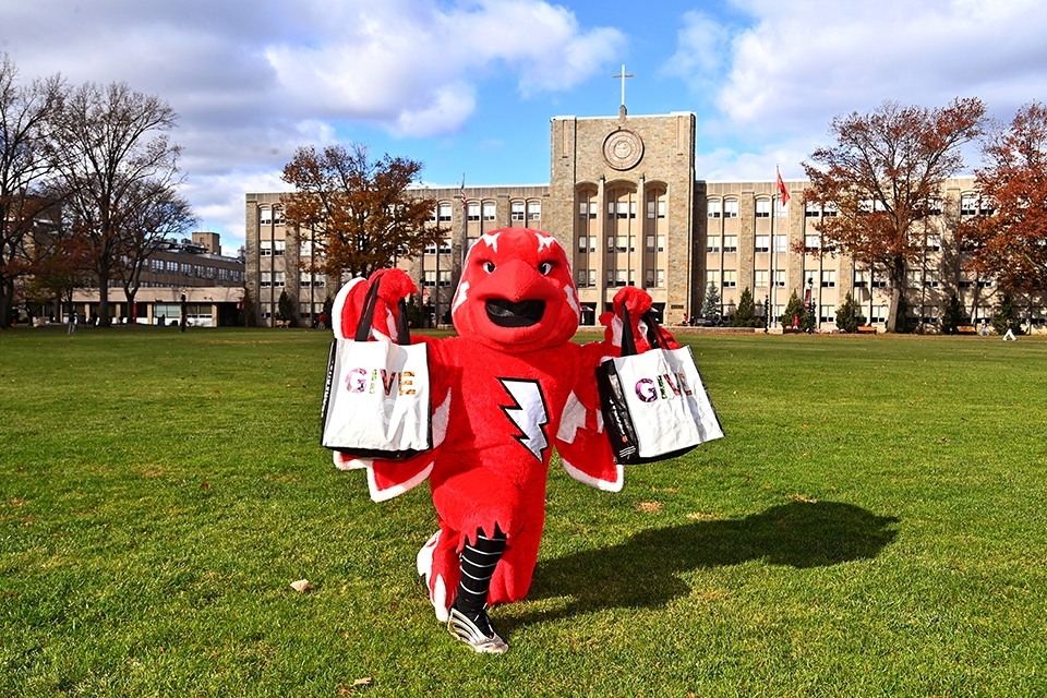 Johnny Thunderbird holding canvas tote bags on Great Lawn