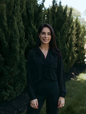 Elin Minasi O'Brien posing in front of evergreen trees