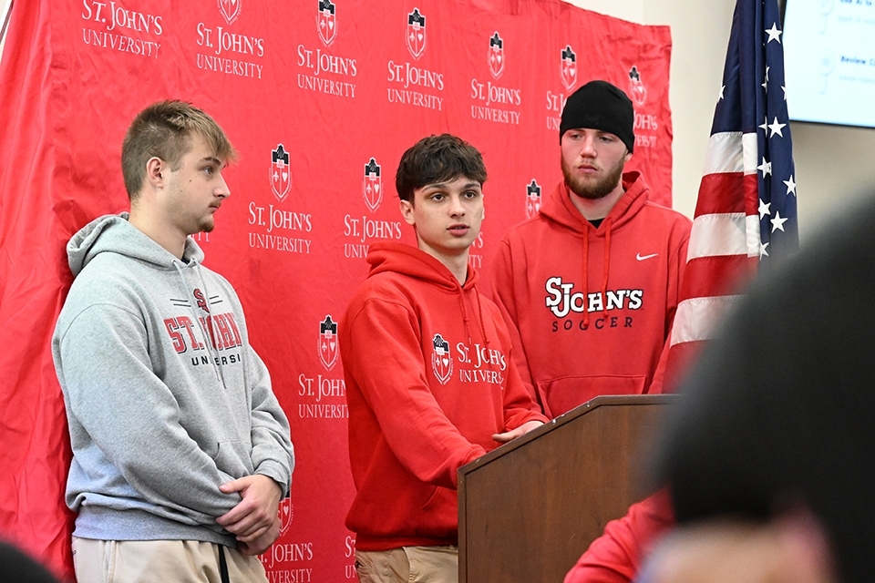 Male high school students speaking at podium